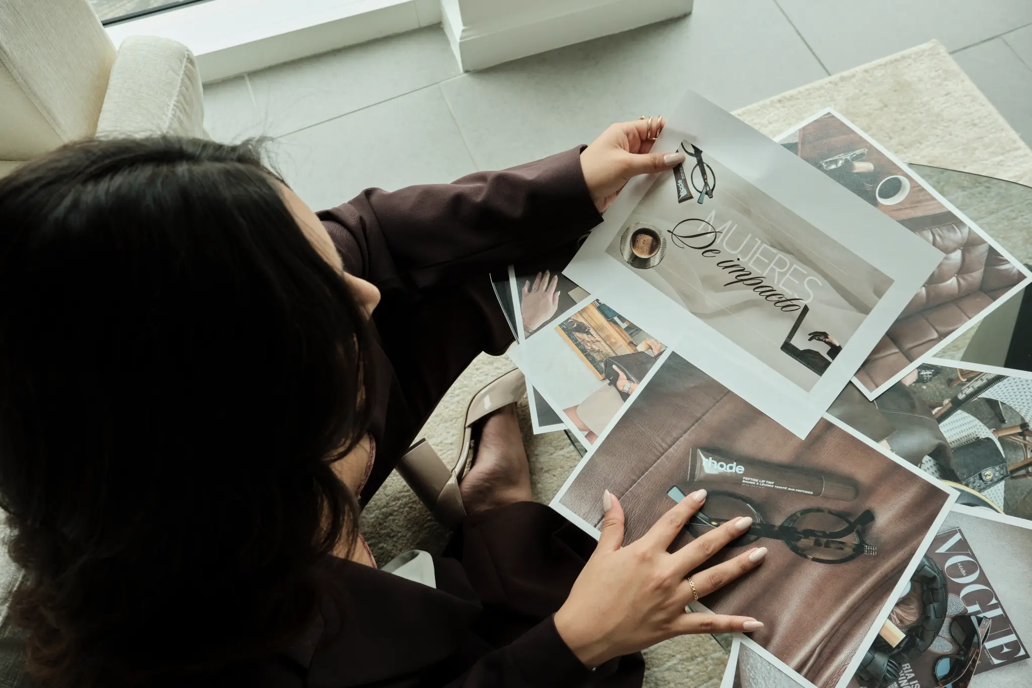 Catherine revisando impresos de marca donde se lee Mujeres de Impacto