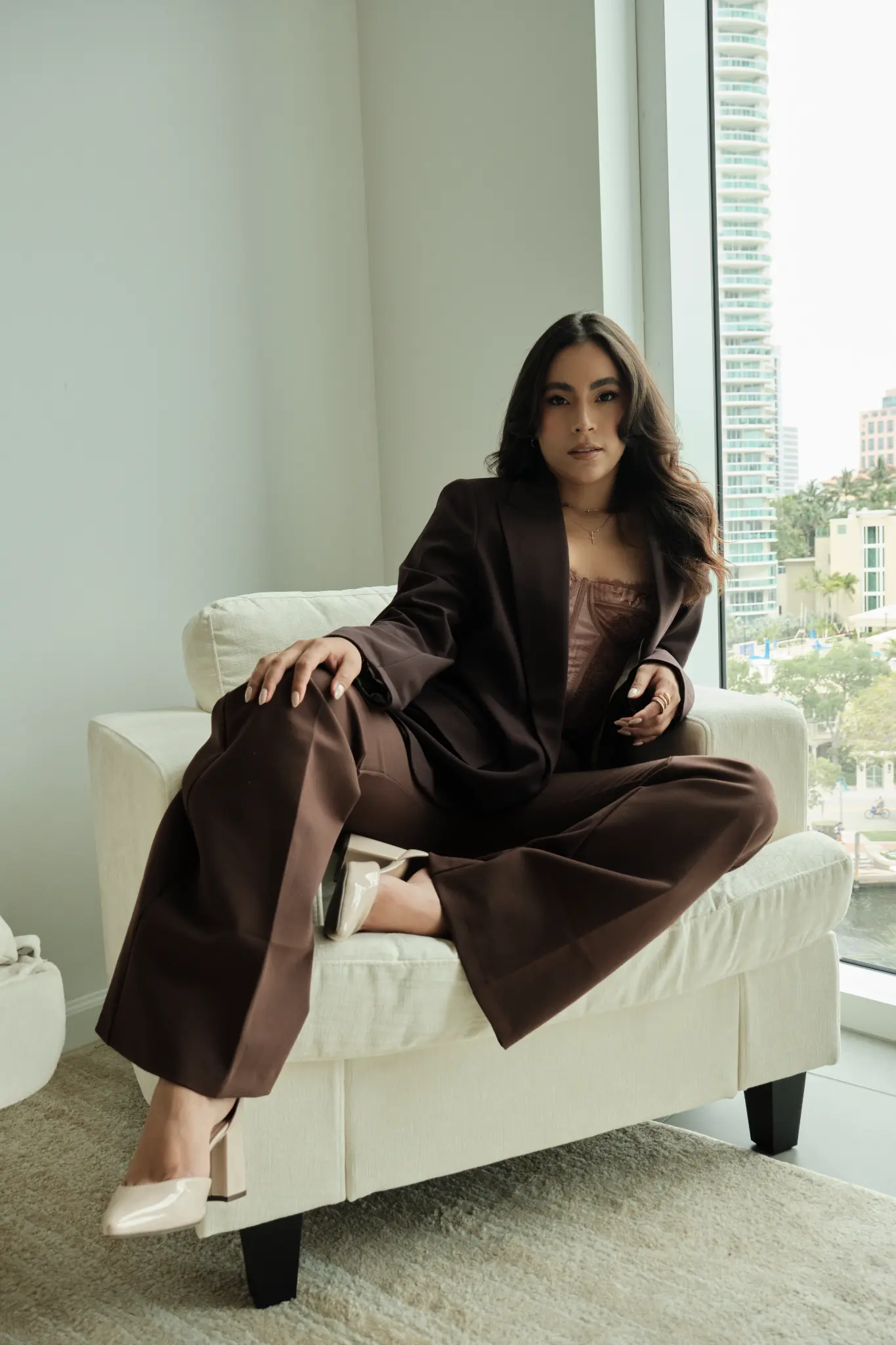 Catherine sentada con seguridad en un sillón frente a la ventana